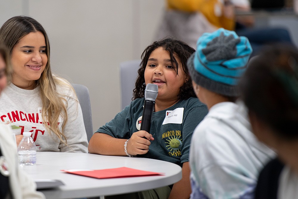 Child speaking into microphone at Fluency Friday 