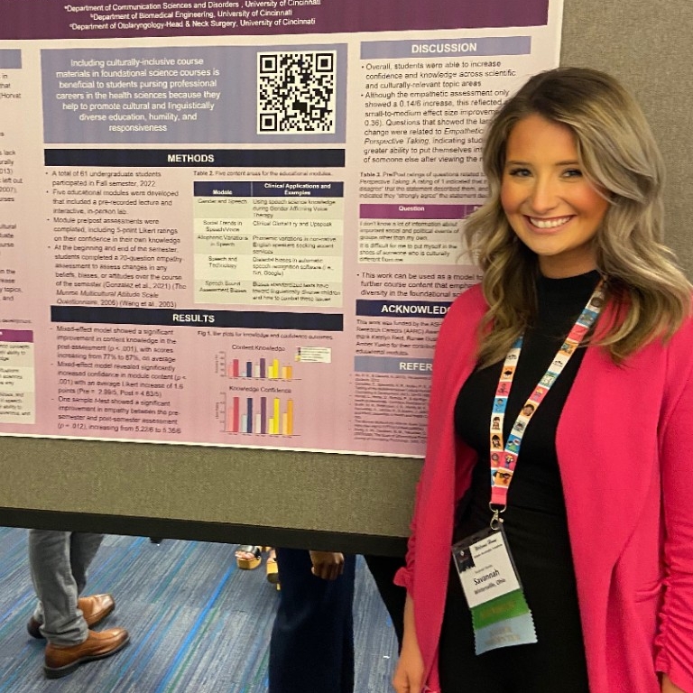Savannah Shanley, Masters of Occupational Therapy student stands in front of poster presentation 