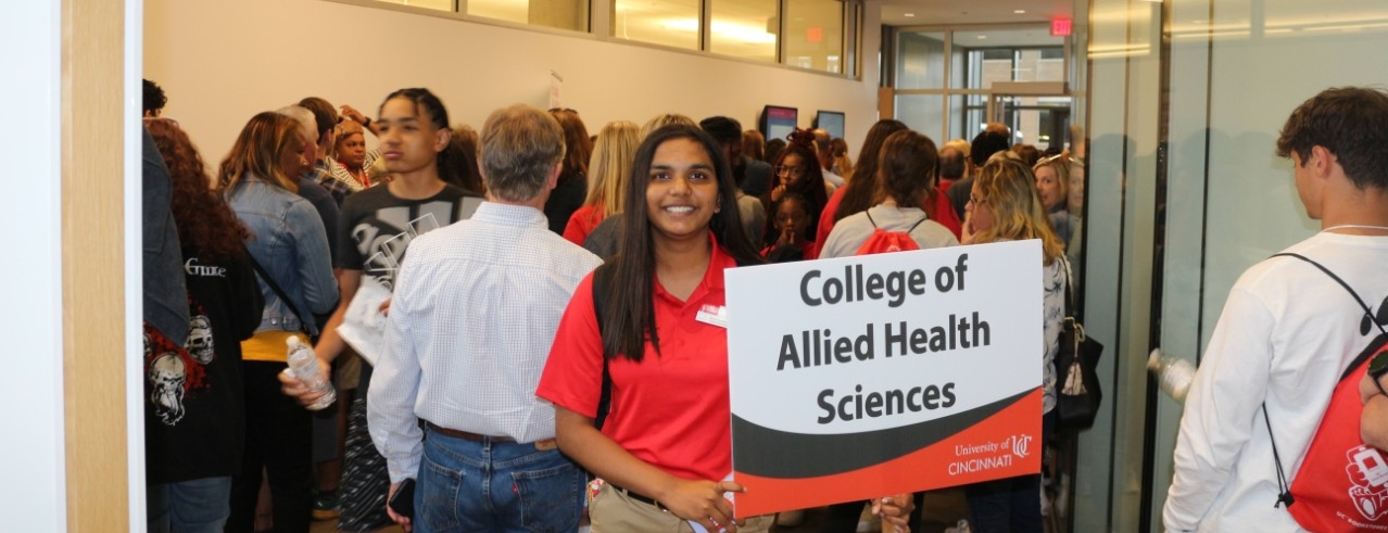 Students Orientation Leader holds a sign that says "College of Allied Health Students" 